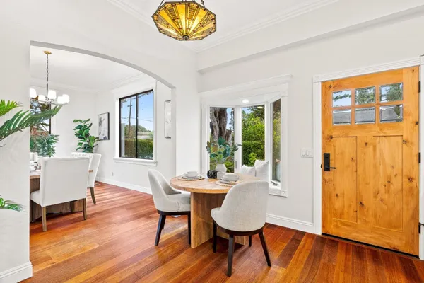 a kitchen with a dining table chairs and white cabinets