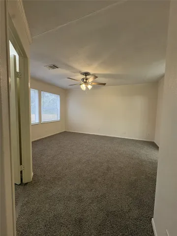 a view of a livingroom with a ceiling fan and window