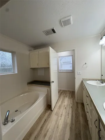 a bathroom with a tub sink and mirror