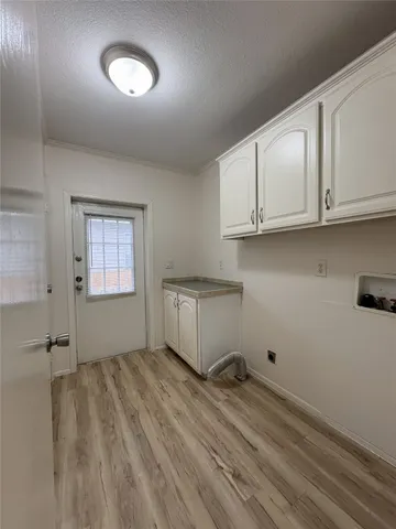 a view of a kitchen with wooden floor and cabinets