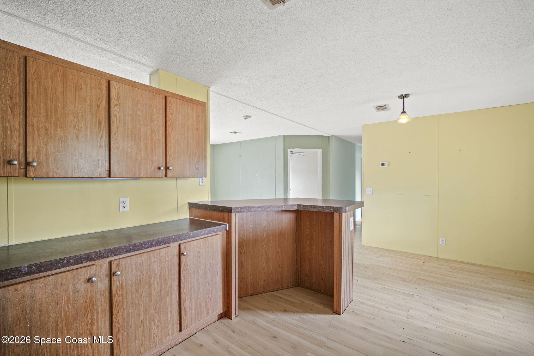 3918 East Ridgewood Drive Cocoa, FL 32926 - Photo 11 of 27 a kitchen with cabinets and wooden floor