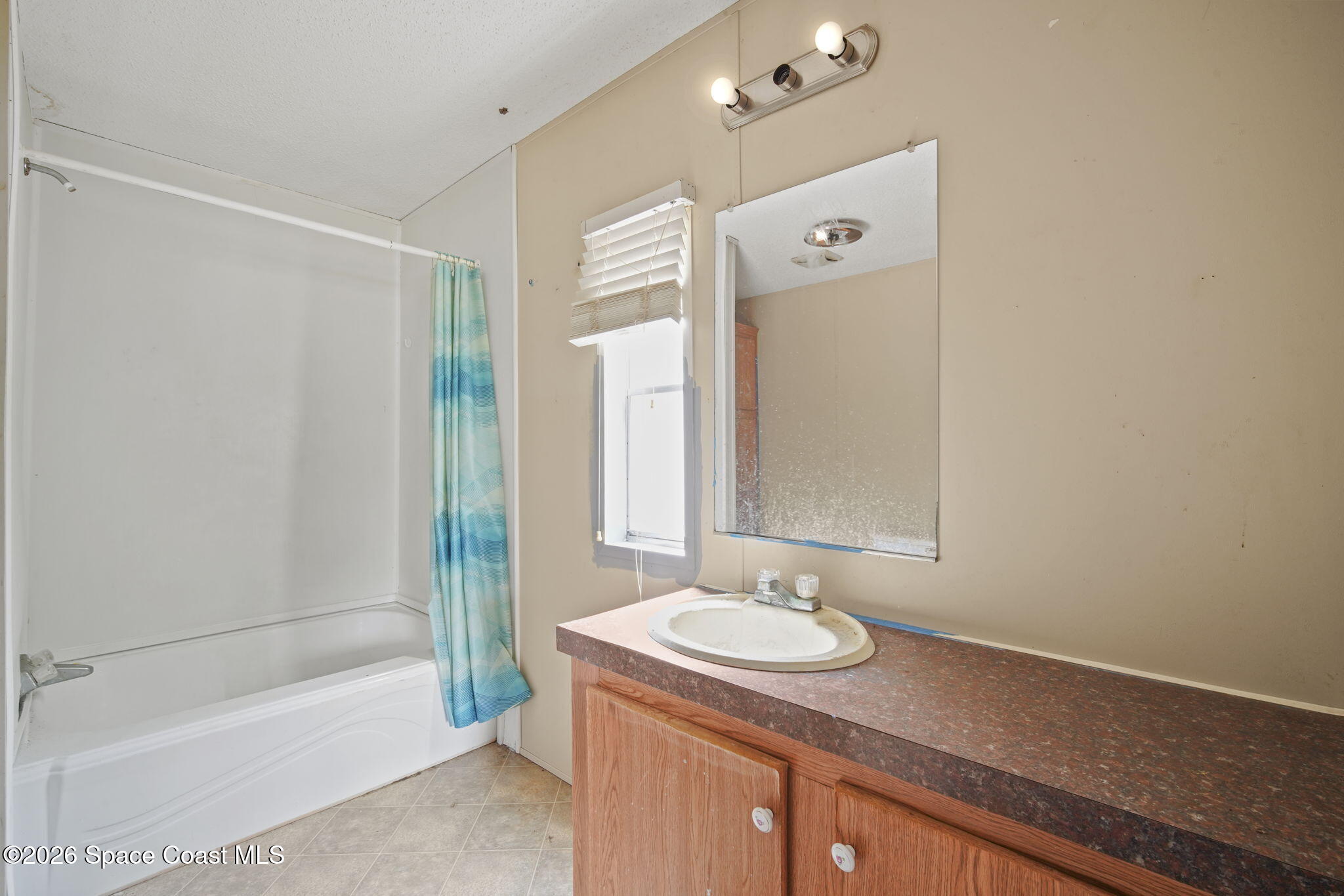 3918 East Ridgewood Drive Cocoa, FL 32926 - Photo 14 of 27 a bathroom with a granite countertop sink and a mirror