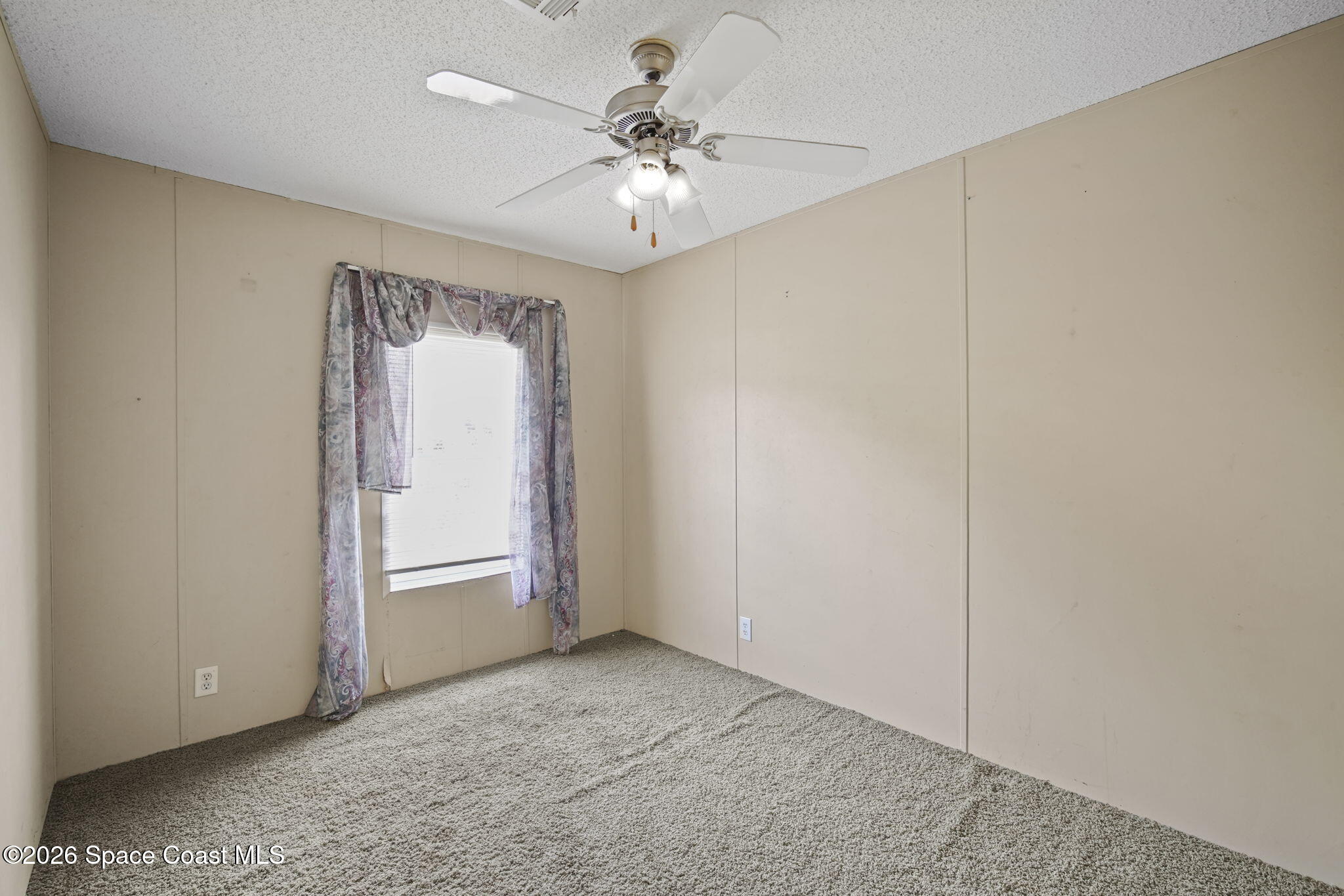 3918 East Ridgewood Drive Cocoa, FL 32926 - Photo 20 of 27 an empty room with chandelier fan and windows