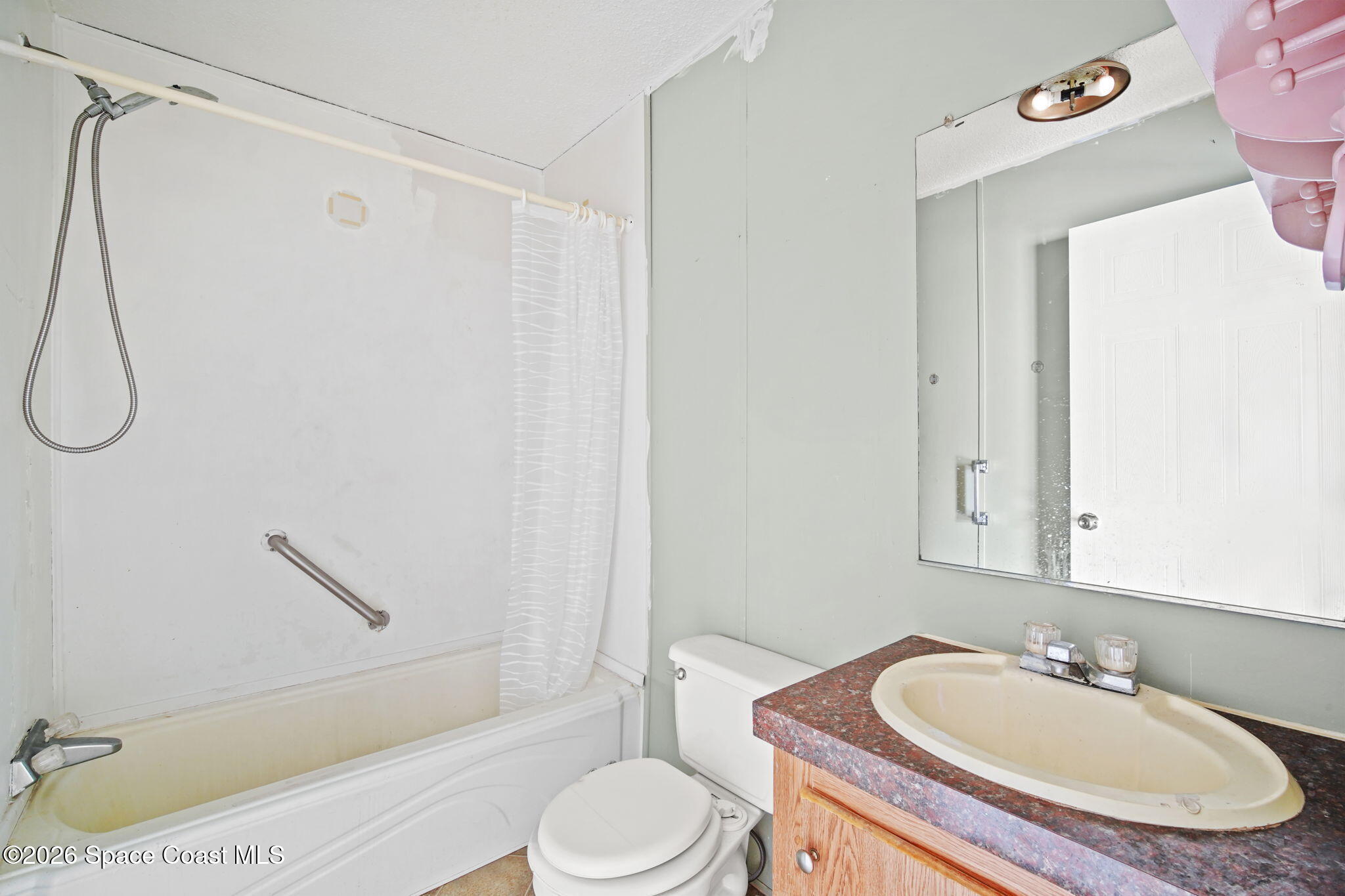 3918 East Ridgewood Drive Cocoa, FL 32926 - Photo 22 of 27 a bathroom with a sink toilet and shower