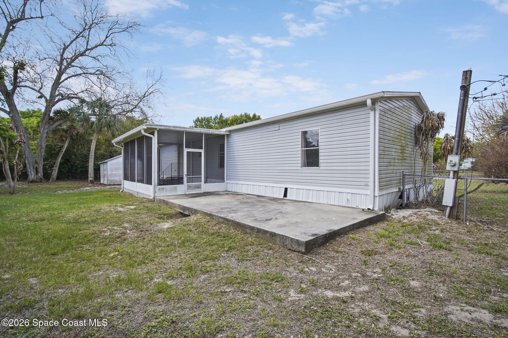 3918 East Ridgewood Drive Cocoa, FL 32926 - Photo 26 of 27 a backyard of a house with table and chairs
