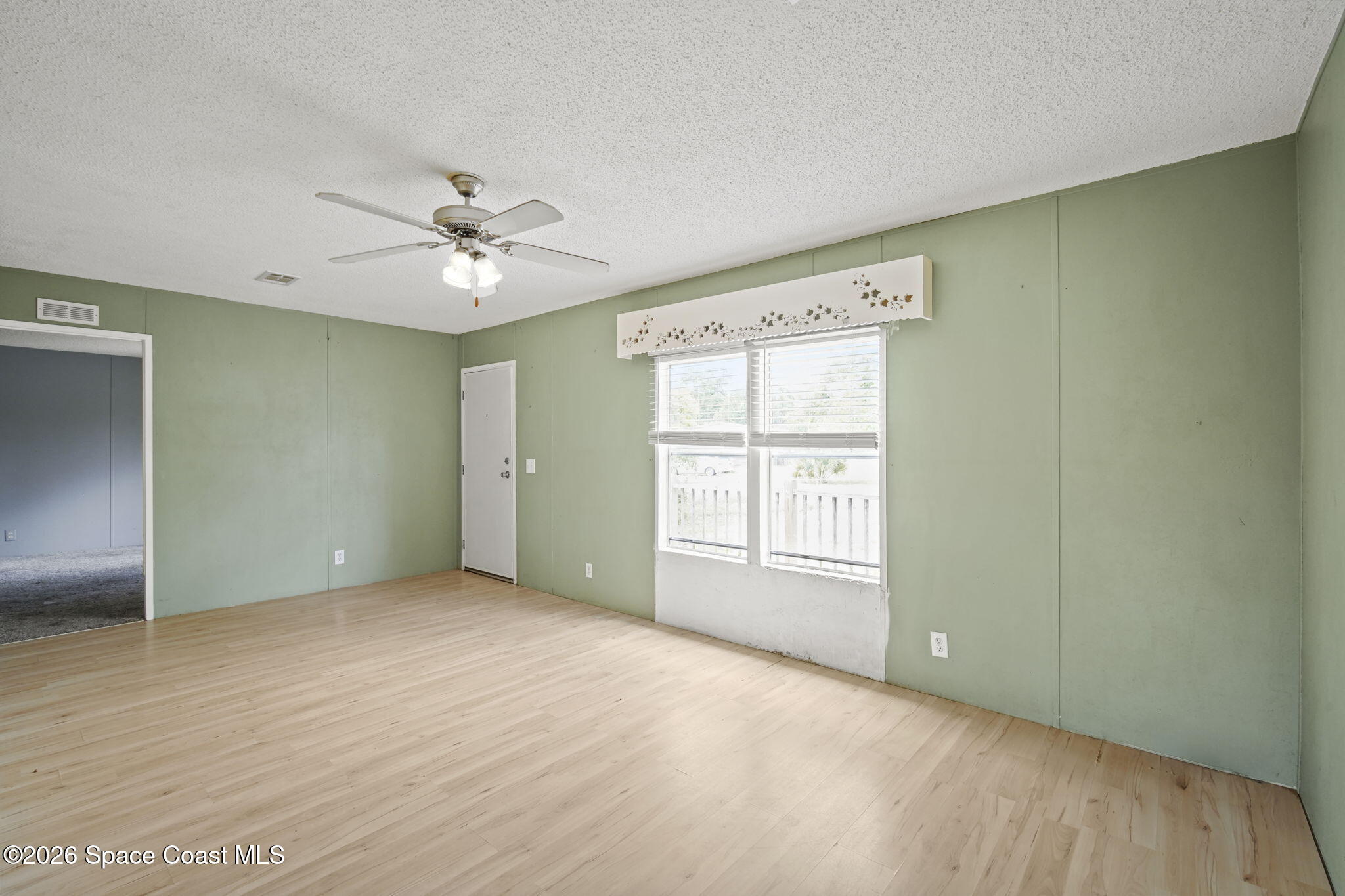 3918 East Ridgewood Drive Cocoa, FL 32926 - Photo 5 of 27 an empty room with chandelier fan and windows