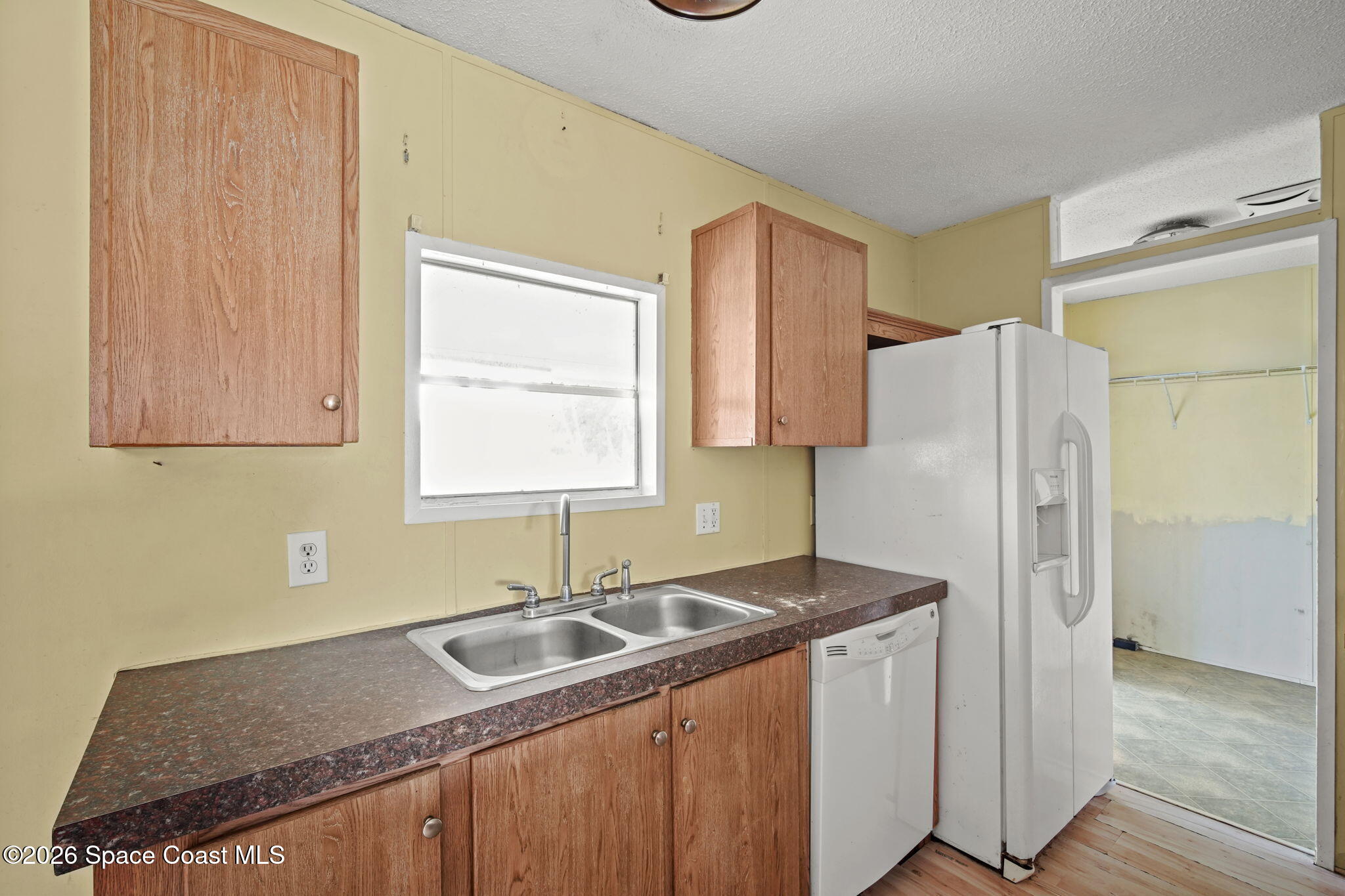 3918 East Ridgewood Drive Cocoa, FL 32926 - Photo 8 of 27 a kitchen with a sink a refrigerator and cabinets