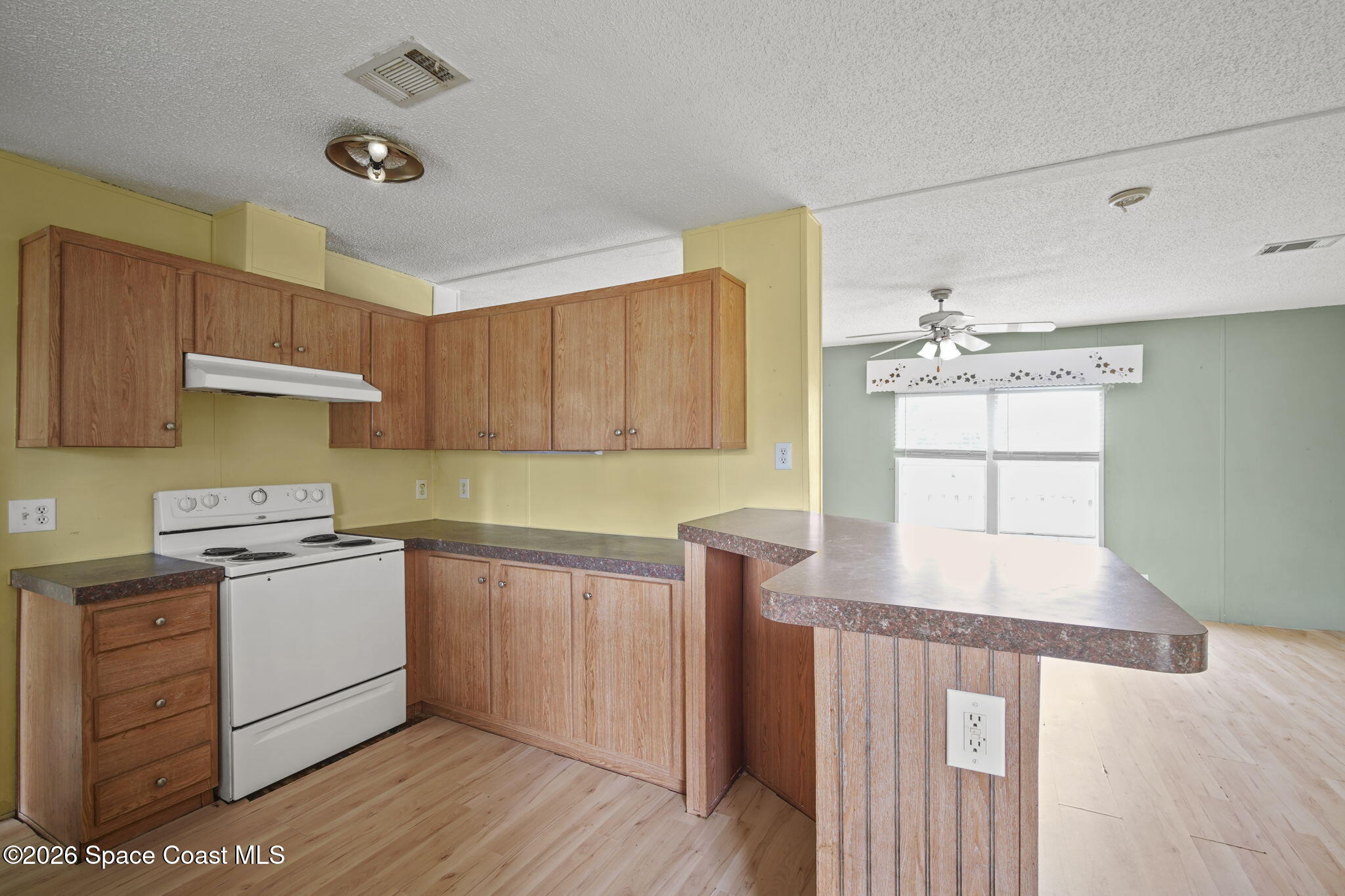 3918 East Ridgewood Drive Cocoa, FL 32926 - Photo 9 of 27 a kitchen with a sink a stove cabinets and wooden floor