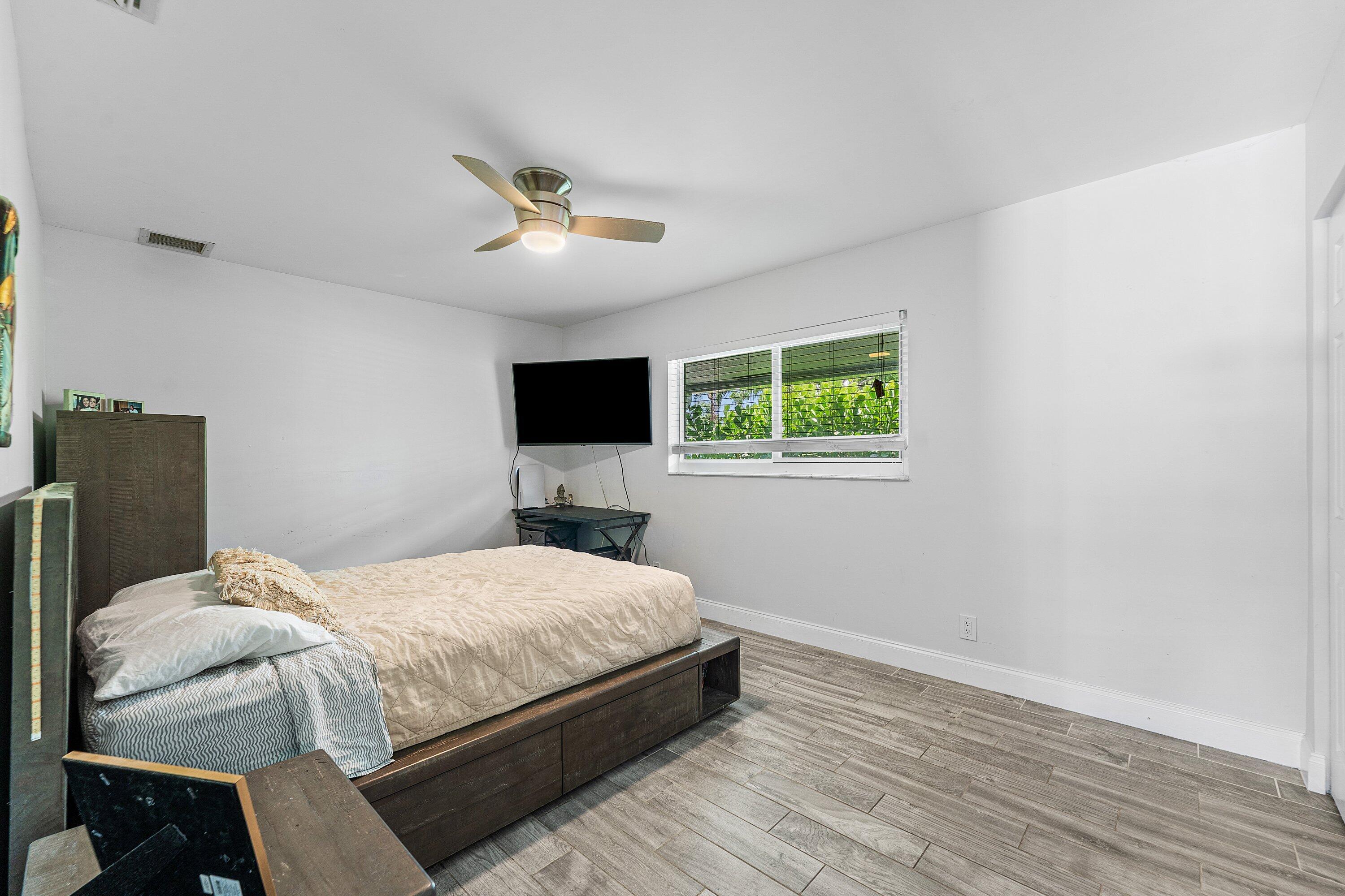 581 Northwest 13th Drive Boca Raton, FL 33486 - Photo 21 of 39 a bedroom with a bed and a flat screen tv