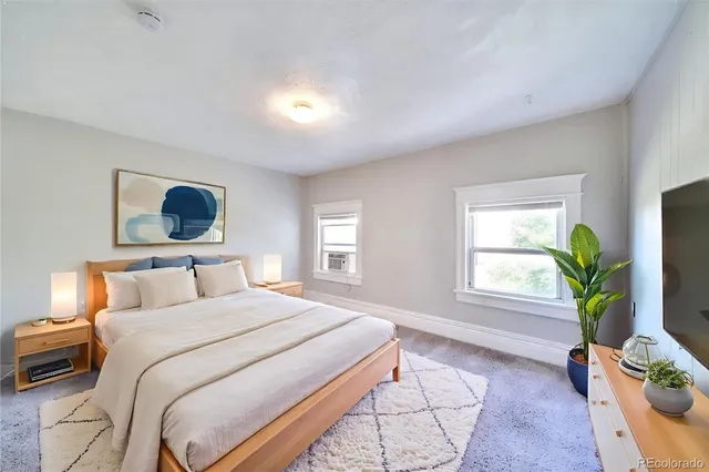a bedroom with a bed table and flat screen tv