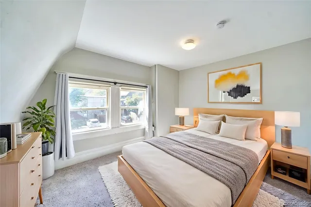 a bedroom with furniture and a large window