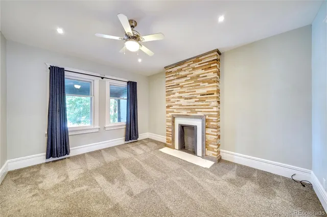a view of an empty room with window and fire place