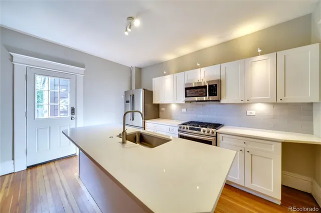 a kitchen with granite countertop a stove a sink and a microwave