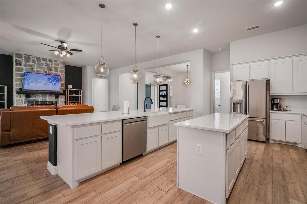 1843 Granite Way Van Alstyne, TX 75495 - Photo 22 of 39 a kitchen with white cabinets and stainless steel appliances