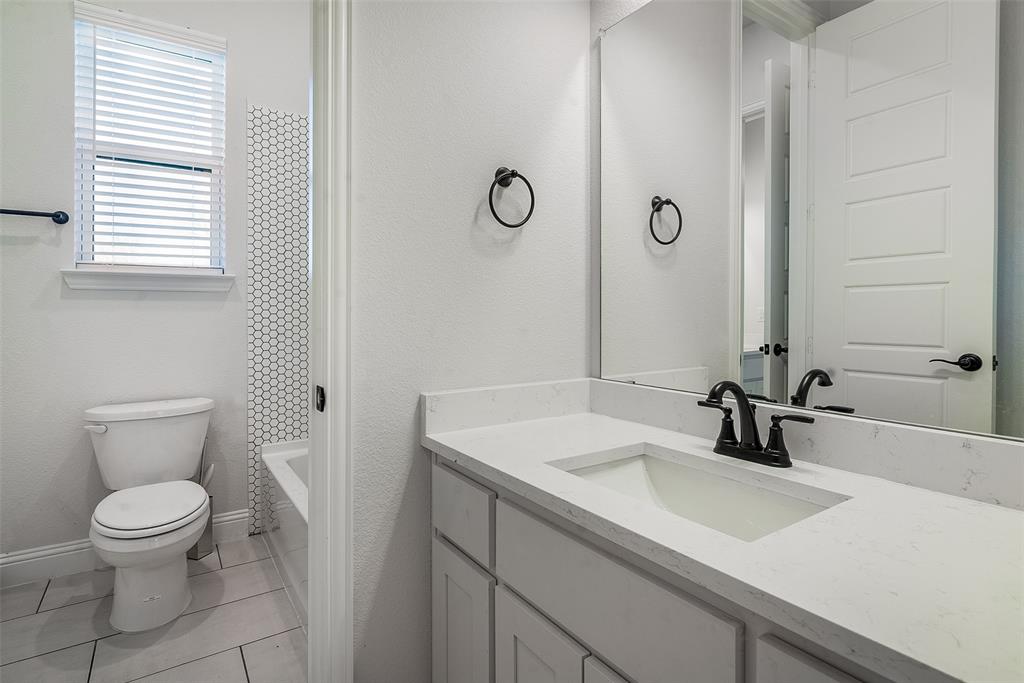 1843 Granite Way Van Alstyne, TX 75495 - Photo 39 of 39 a bathroom with a sink a toilet and a mirror
