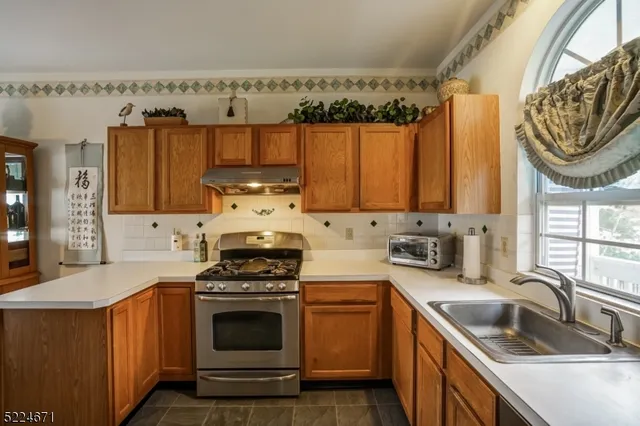 a kitchen with granite countertop a sink a stove and cabinets