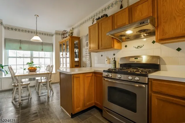 a kitchen with a stove a sink and chairs