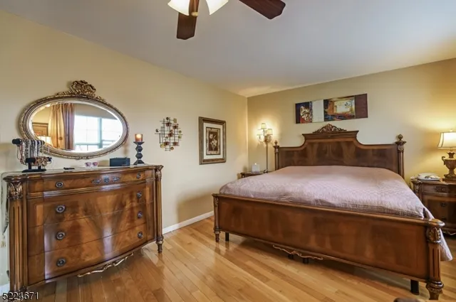 a bedroom with a bed a mirror on dresser and a chandelier
