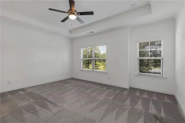 an empty room with windows and fan