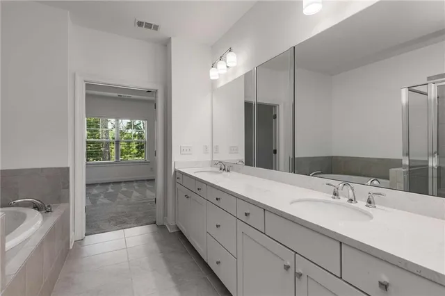 a bathroom with a tub sink and mirror