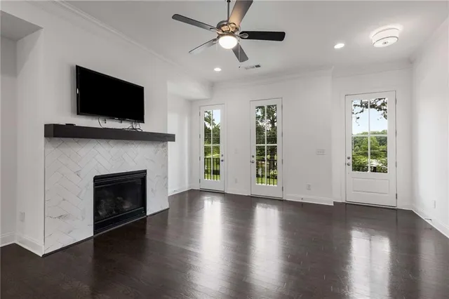 a view of an empty room with wooden floor fireplace and a window