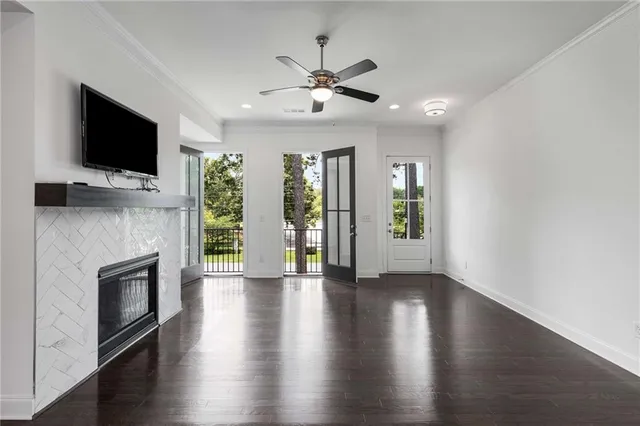 a view of an empty room with wooden floor fireplace and a window