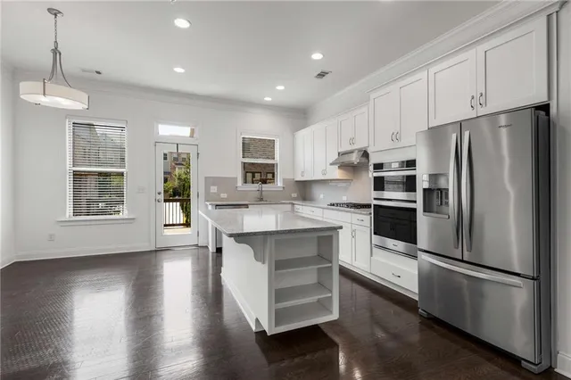 a kitchen with stainless steel appliances a refrigerator sink and microwave
