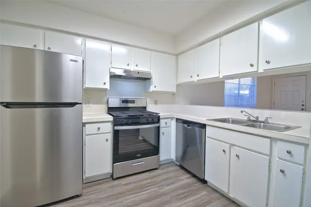 a kitchen with a sink stainless steel appliances and cabinets
