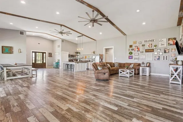 a living room with lots of furniture and view of kitchen