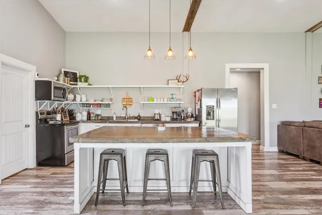 a dining table with chairs and kitchen view