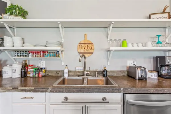 a kitchen with stainless steel appliances granite countertop a refrigerator a stove and a wooden floors