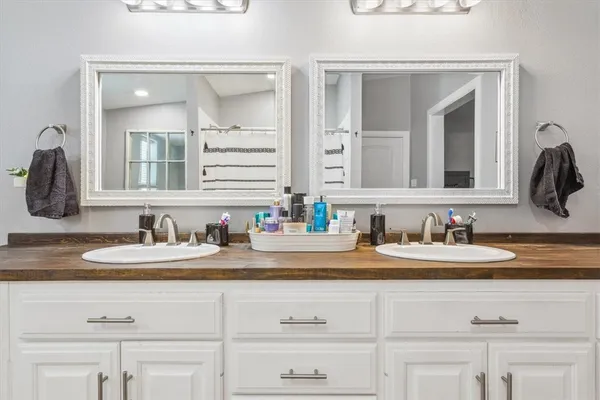 a bathroom with a double vanity sink and a mirror