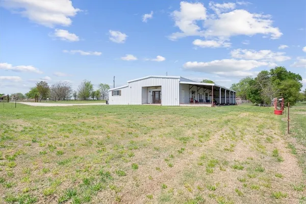 a view of a large white house with a yard