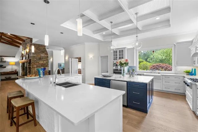 a large white kitchen with lots of counter space a sink and appliances