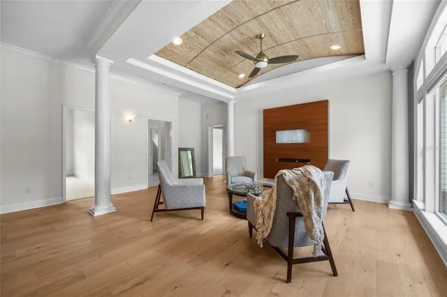 a living room with furniture a large window and wooden floor