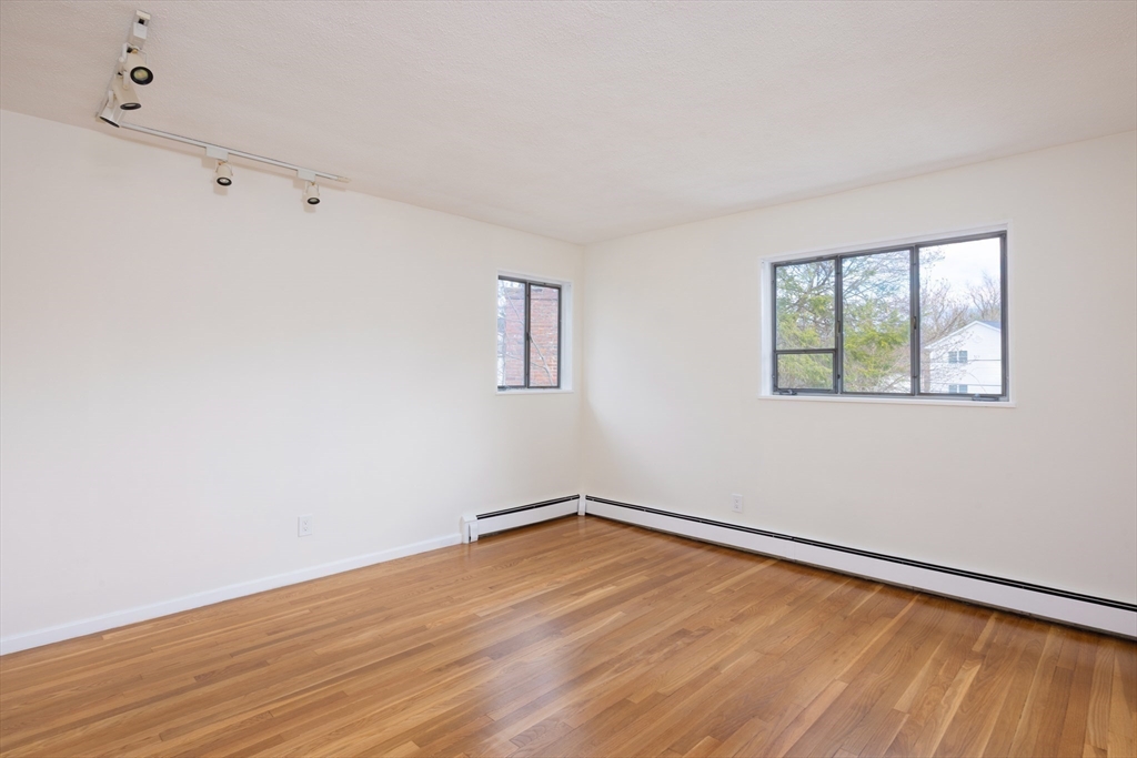 535 Clinton Road Brookline, MA 02467 - Photo 9 of 12 a view of empty room with wooden floor and fan