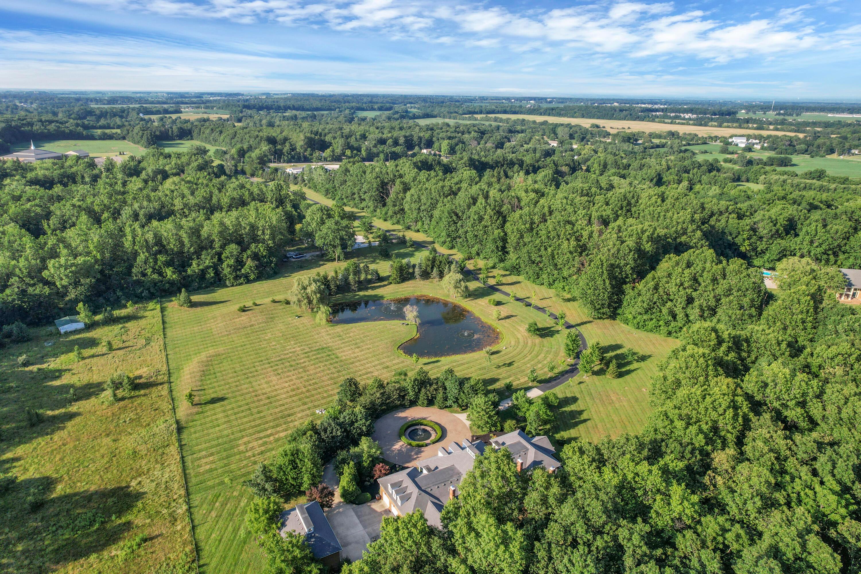 3575 State Rte 37 West Delaware, OH 43015 - Photo 17 of 106 Expansive property featuring a private pond, mature trees, manicured lawns, a circular driveway, and a large residence