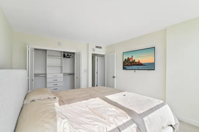 a bedroom with a bed and a painting on the wall