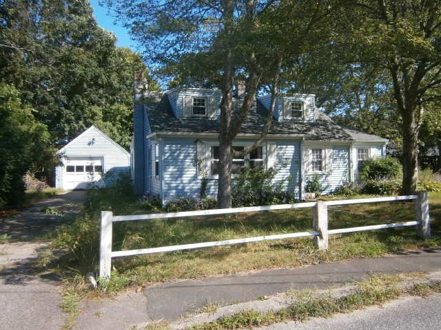 a view of backyard with wooden fence and large trees