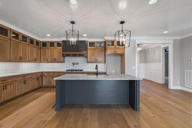 a large kitchen with cabinets wooden floor and stainless steel appliances