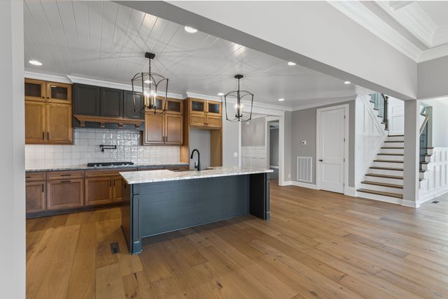 a large kitchen with stainless steel appliances granite countertop a sink and a stove