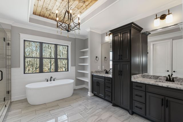 a spacious bathroom with a tub sink and mirror