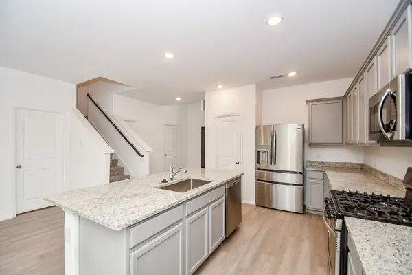 a kitchen with stainless steel appliances granite countertop a refrigerator a stove a sink and a refrigerator