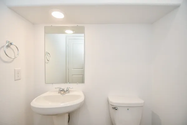 an empty room with wooden floor closet and windows