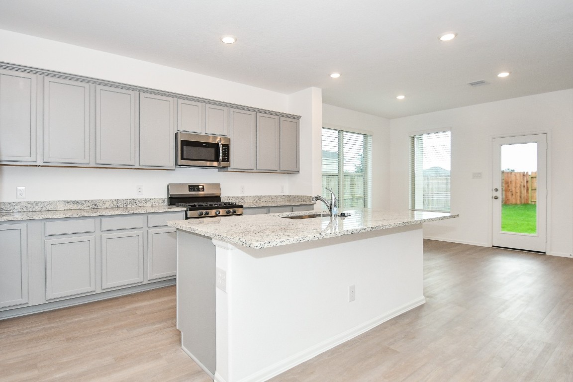 5240 Pine Pass Drive Rosenberg, TX 77469 - Photo 16 of 32 a kitchen with stainless steel appliances granite countertop a stove a sink and a microwave