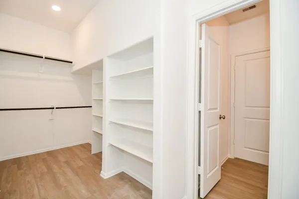a view of walk in closet with empty racks