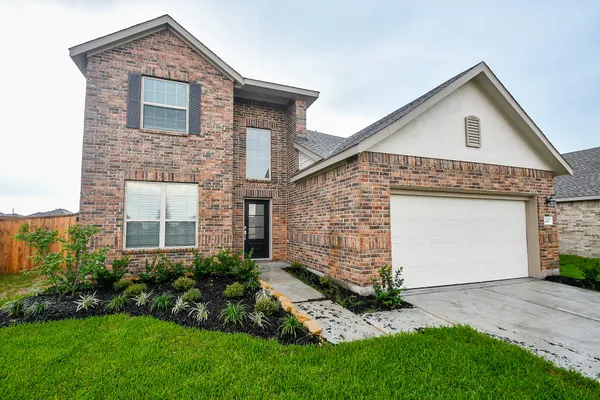 a front view of a house with a garden and plants