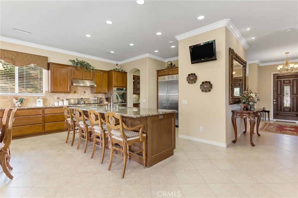 9841 Kehl Canyon Road Beaumont, CA 92223 - Photo 14 of 57 a dining hall with stainless steel appliances a dining table chairs and a refrigerator