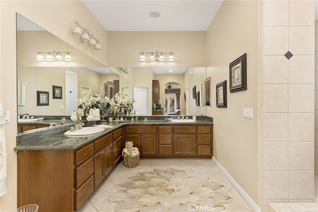 9841 Kehl Canyon Road Beaumont, CA 92223 - Photo 39 of 57 a spacious bathroom with a granite countertop sink and a mirror