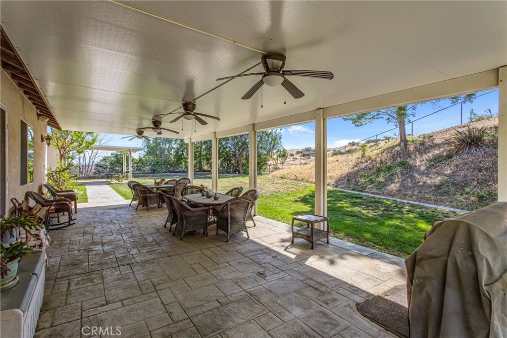 9841 Kehl Canyon Road Beaumont, CA 92223 - Photo 42 of 57 a view of a patio with table and chairs potted plants with floor to ceiling window